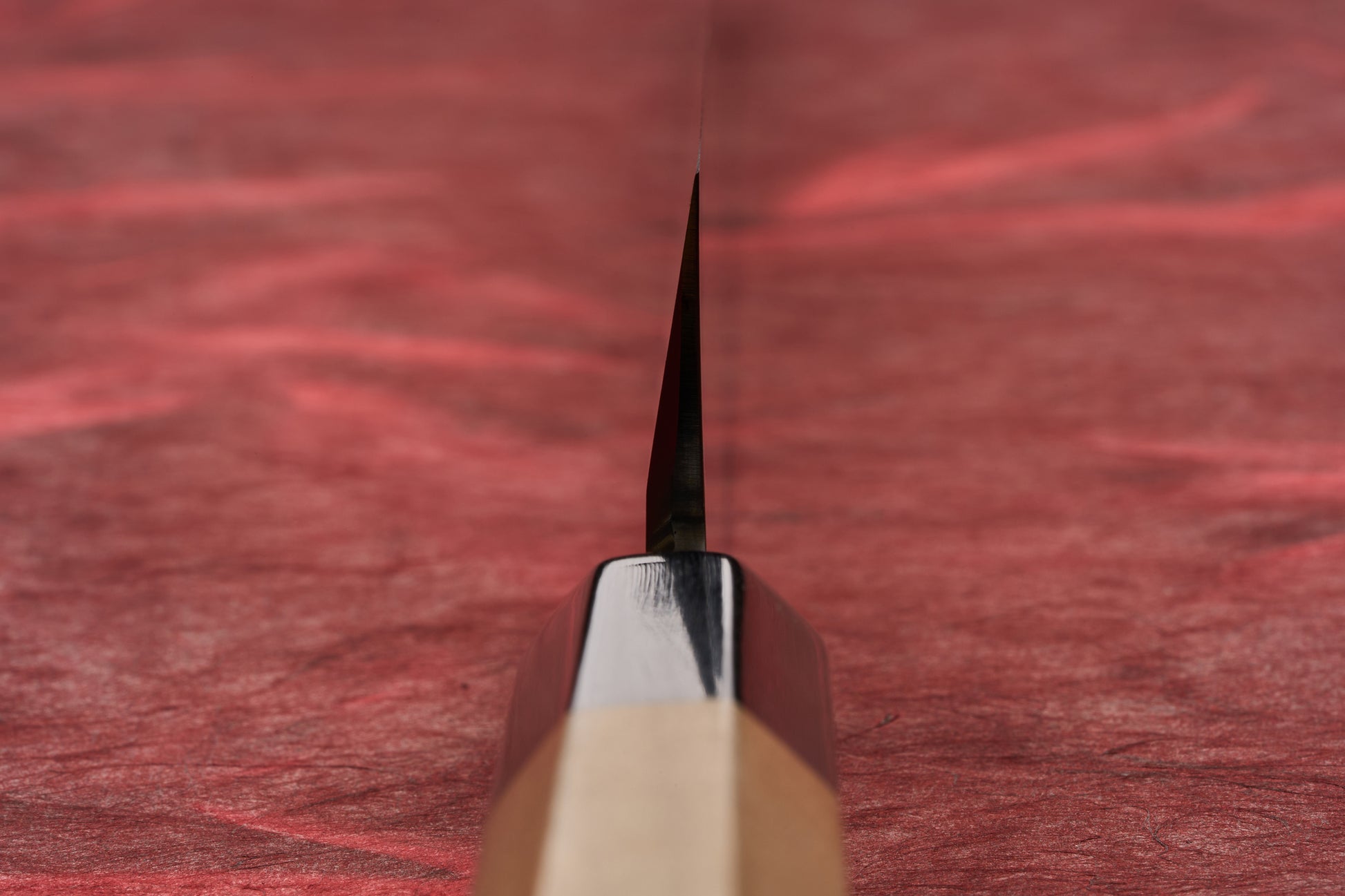 Touroku Sakai Tohwa Shirogami Yanagiba 270mm, a Japanese-style kitchen knife with an octagonal wooden handle, elegantly laid on a red surface, showcasing its single-bevel blade designed for precise slicing.