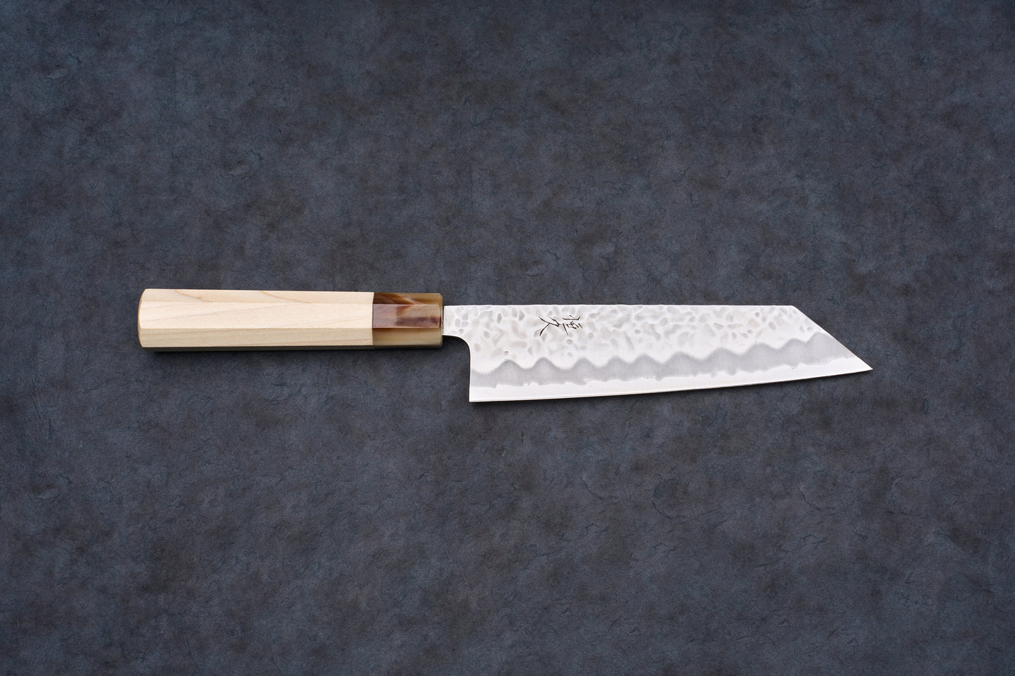 Tsunehisa Shiroichi Stainless Nijuhachi 廿捌 Tsuchime Bunka 165mm knife, featuring a hammered blade and octagonal wood handle, on a dark surface.
