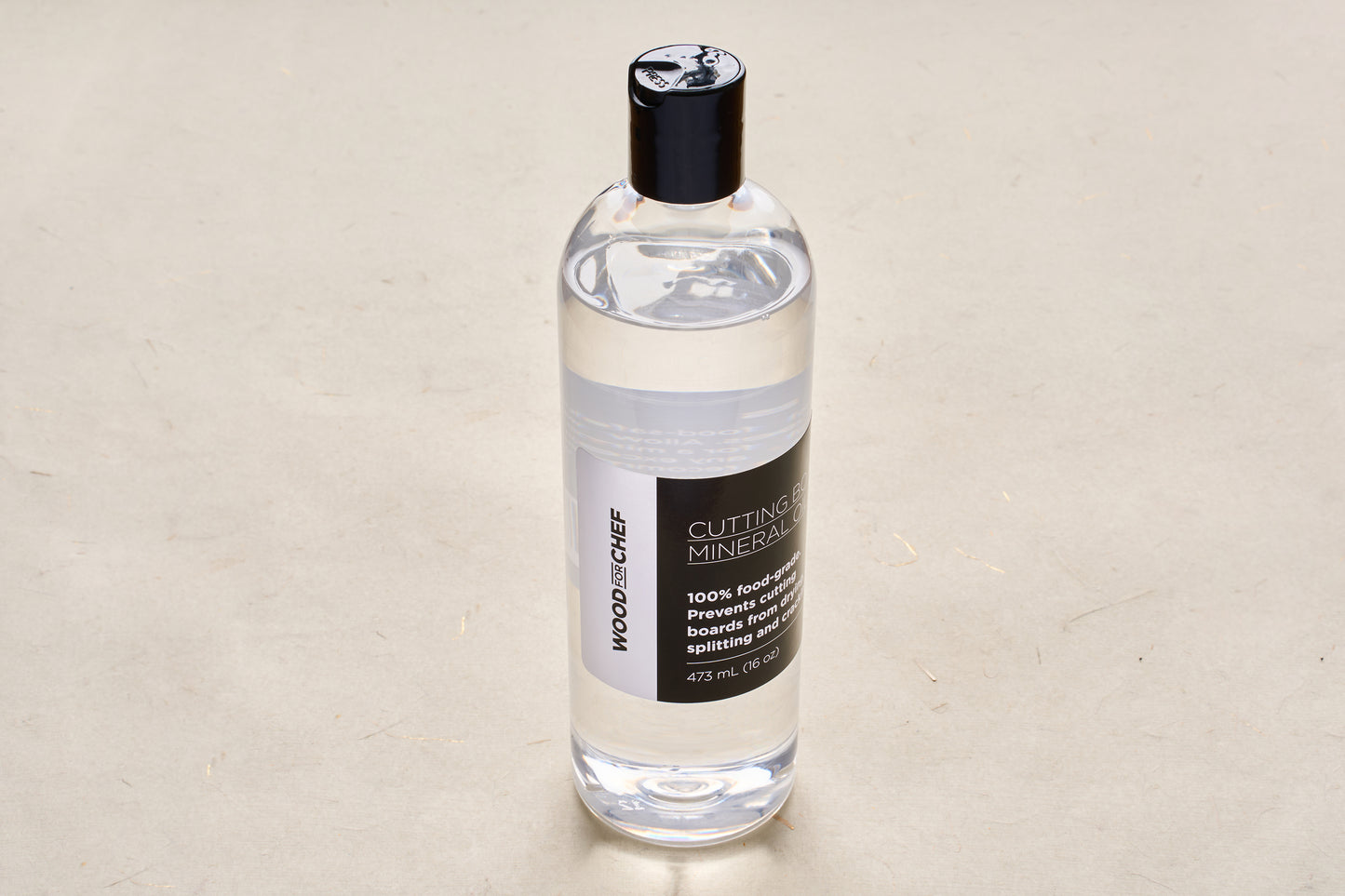 WoodforChef Cutting Board Mineral Oil in a clear bottle with a black cap, ideal for conditioning wooden boards. Food-grade, 473 mL.
