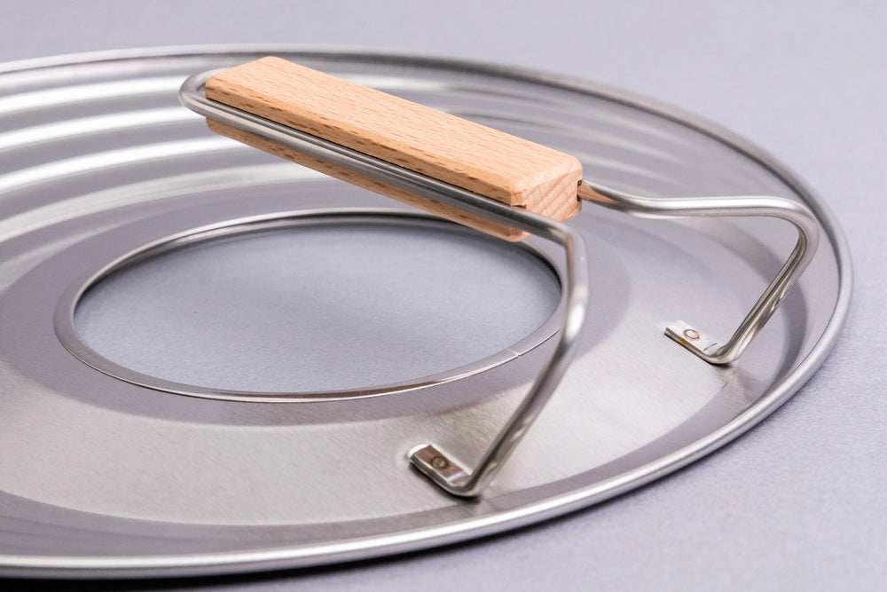 Fujita Kinzoku Stainless Steel Universal Lid featuring a round design with a wooden handle, held by metal brackets, and a glass window for easy food monitoring. Ideal for versatile kitchen use.