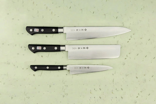 Tojiro Classic 3 Piece Knife Set featuring a gyuto, nakiri, and petty knife, all with stainless steel blades and black riveted handles, perfect for versatile culinary tasks.